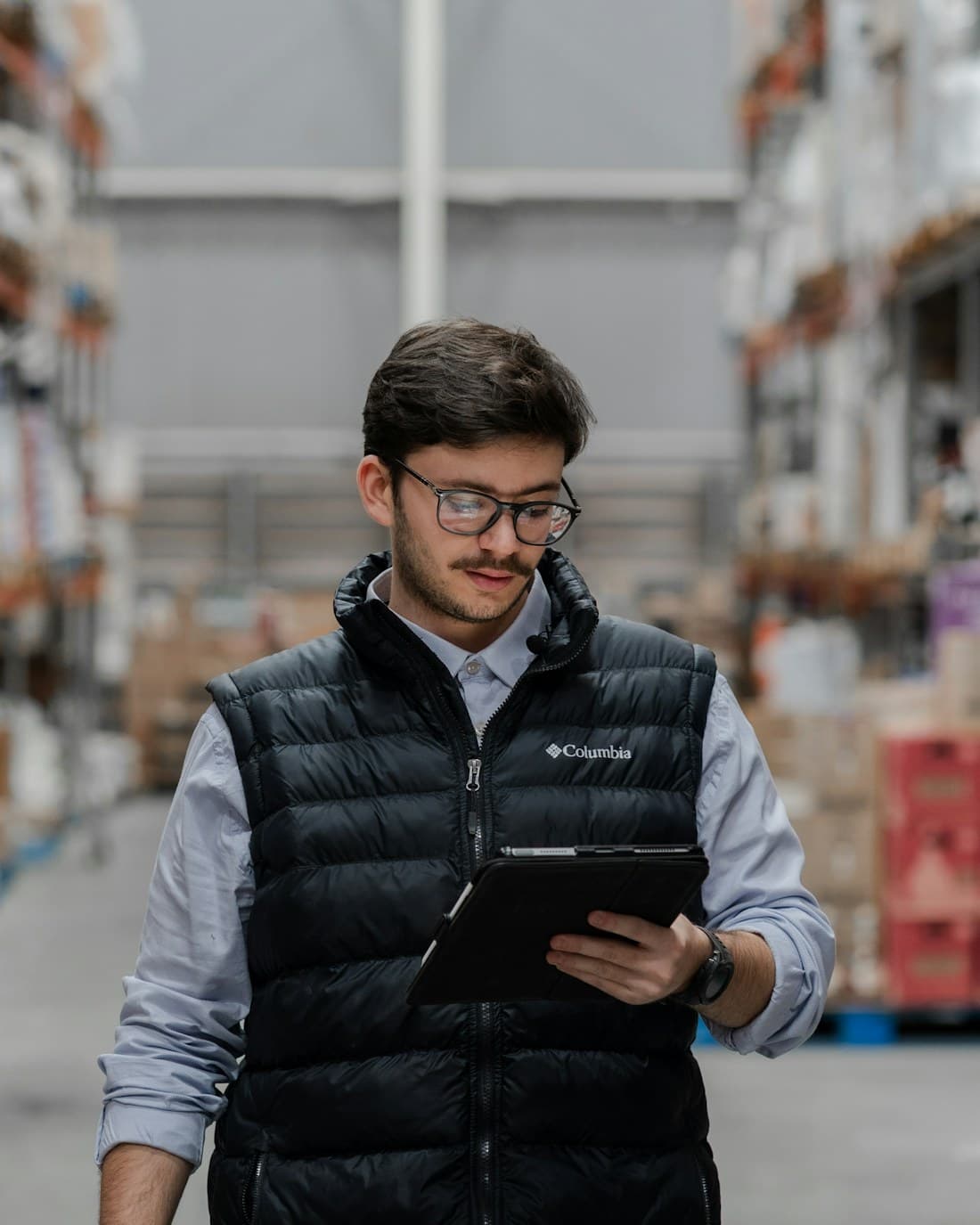 A warehouse manager checking orders on a tablet